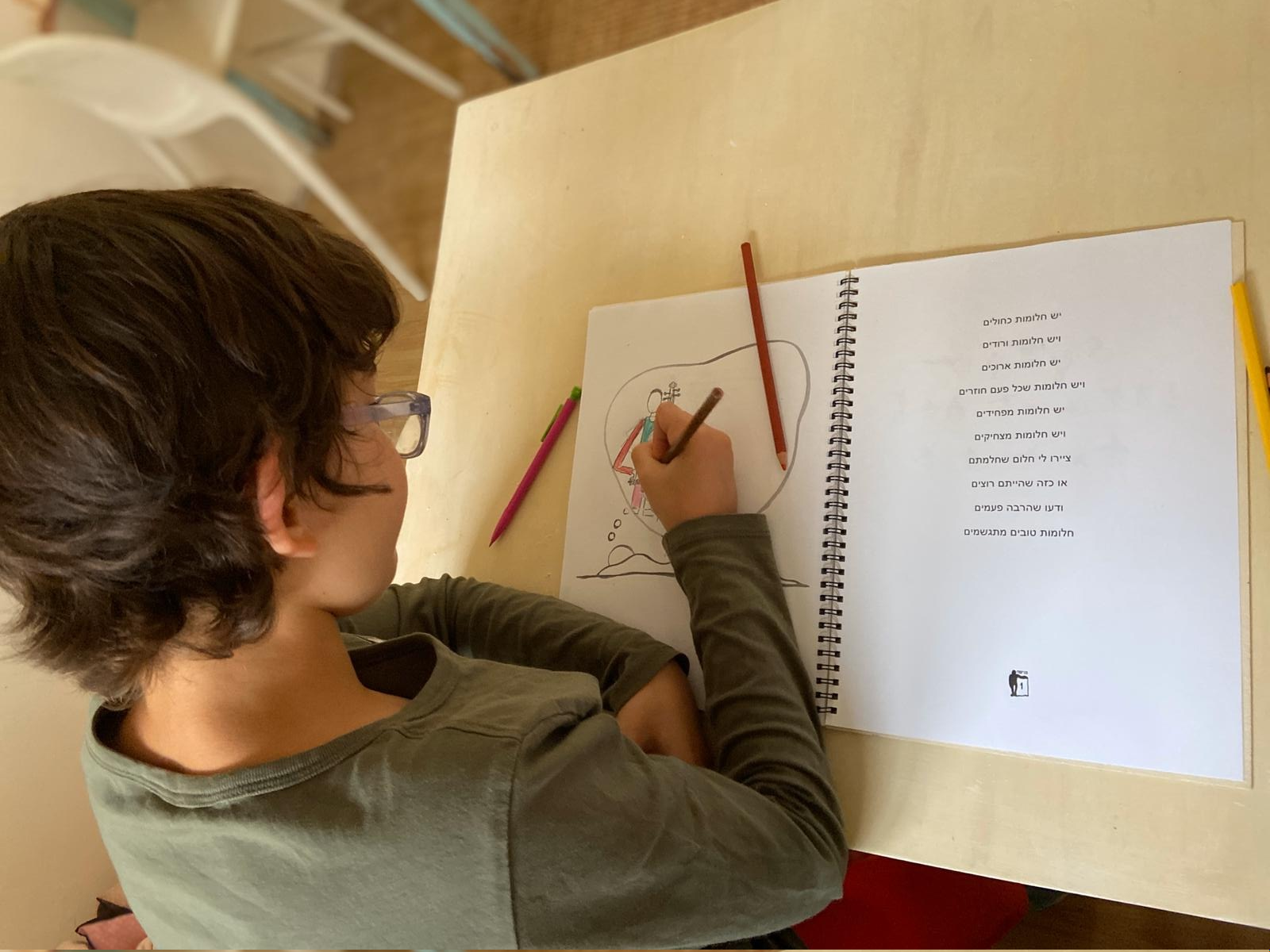 ילד מצייר בחוברת פגישה עם עצמי